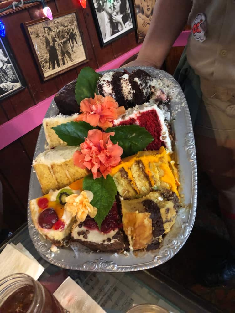 The Bubble Room is one of the most iconic restaurants in Sanibel, or near Sanibel. It is known for its massive desserts, as shown in this photo: a sampler of over eight types of cake is being carried to a table on a silver platter by a server. 