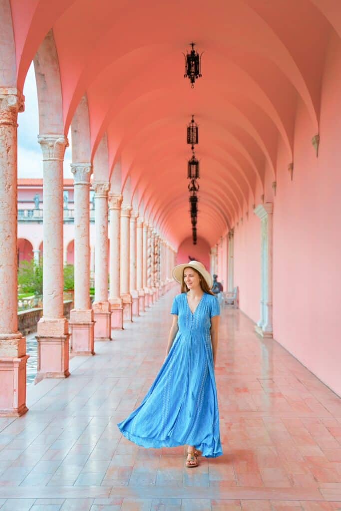 woman standing in front of the ringling museum in florida wearing a blue dress