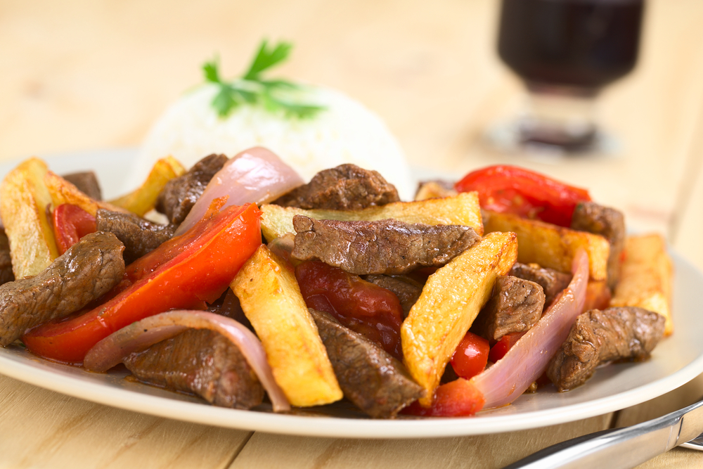 Plate of Lomo Saltado, a Peruvian dish with streak strips, onions, and fries.