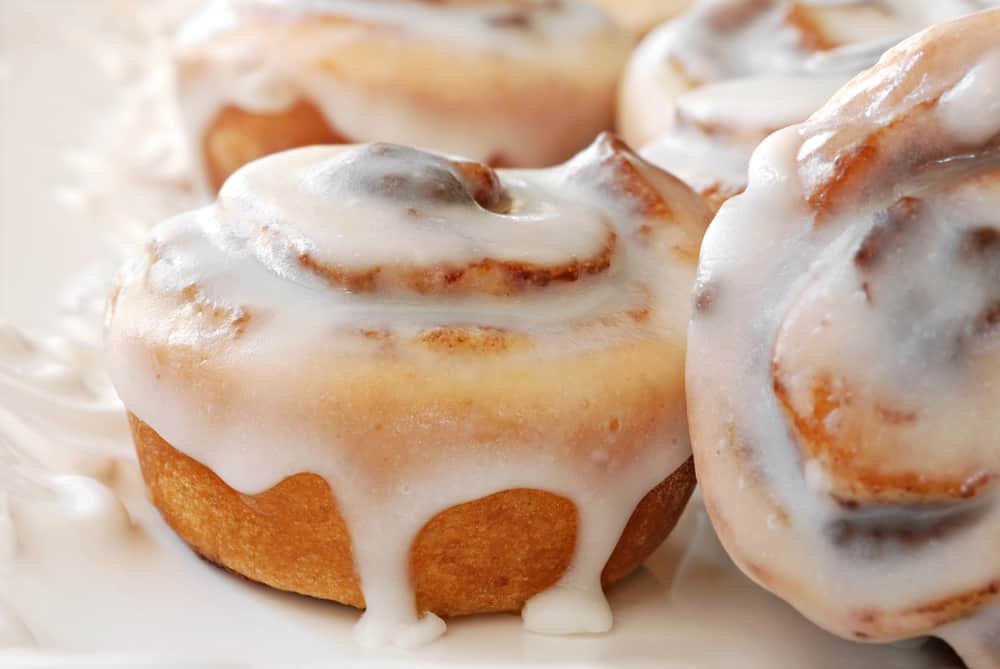 Cinnamon buns drizzled in icing.