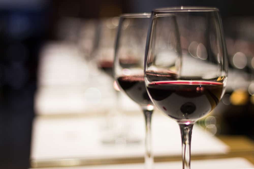 Line of partially full wine glasses at a tasting.