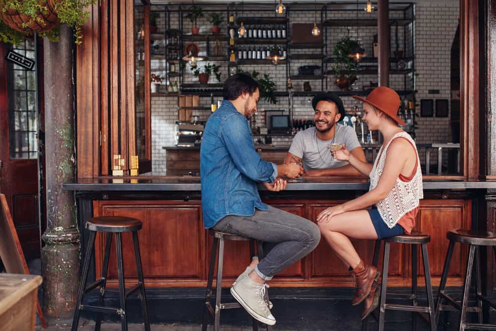 A couple sits at one of the more modern bars in Gainesville nursing two drinks while also engaging in conversation with the bartender. 