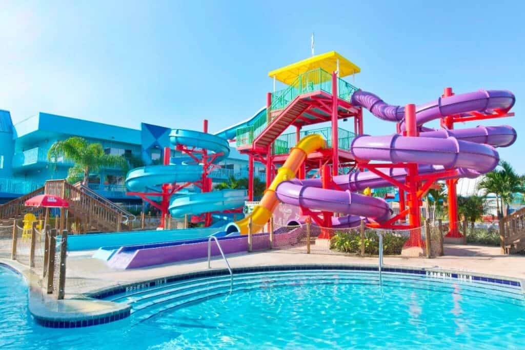 A colorful tangled blob of waterslides above a pool, the slides are purple and blue and yellow and orange 