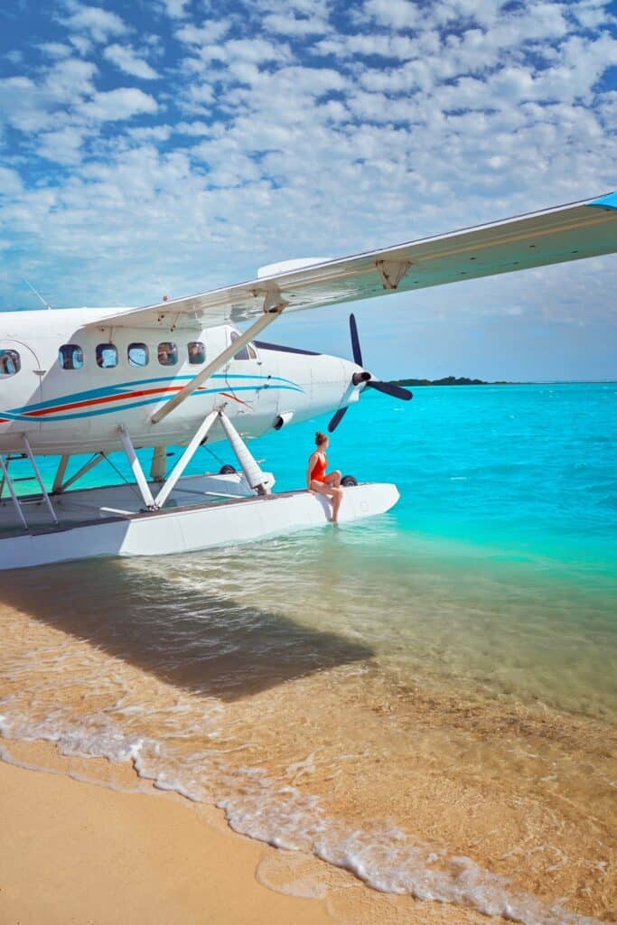 a girl in red swim suit sitting on a White Sea plane in the ocean