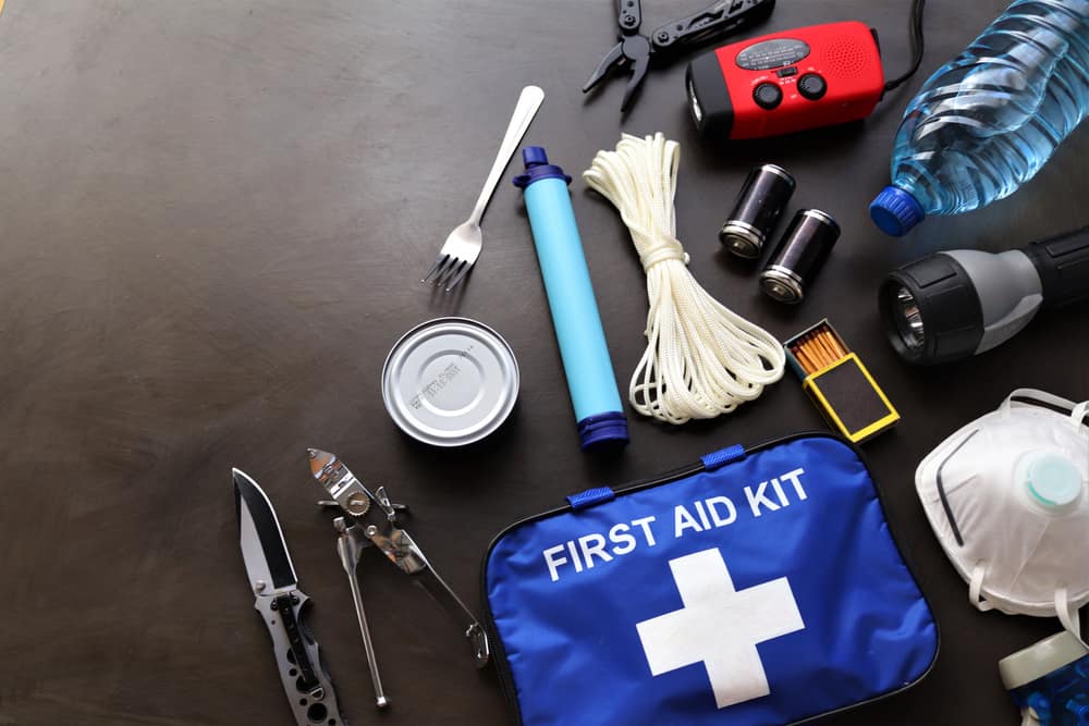 Some items-- like a first aid kit, rope, water, and more-- are laid out on a table for packing a hurricane preparedness list. 