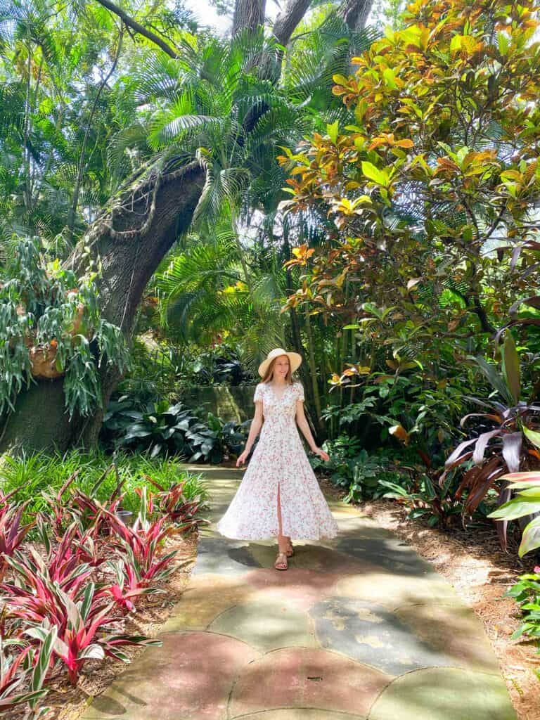 A woman in a dress walks a colorful path through the Sunken Gardens.