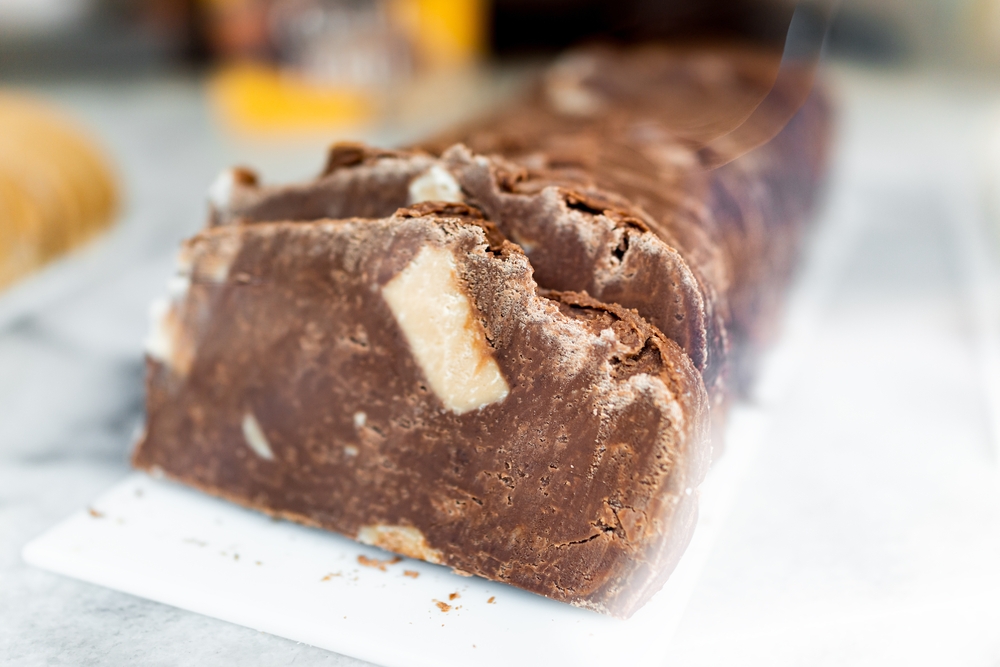 A closeup of homemade milk chocolate fudge, cut into thick slices.