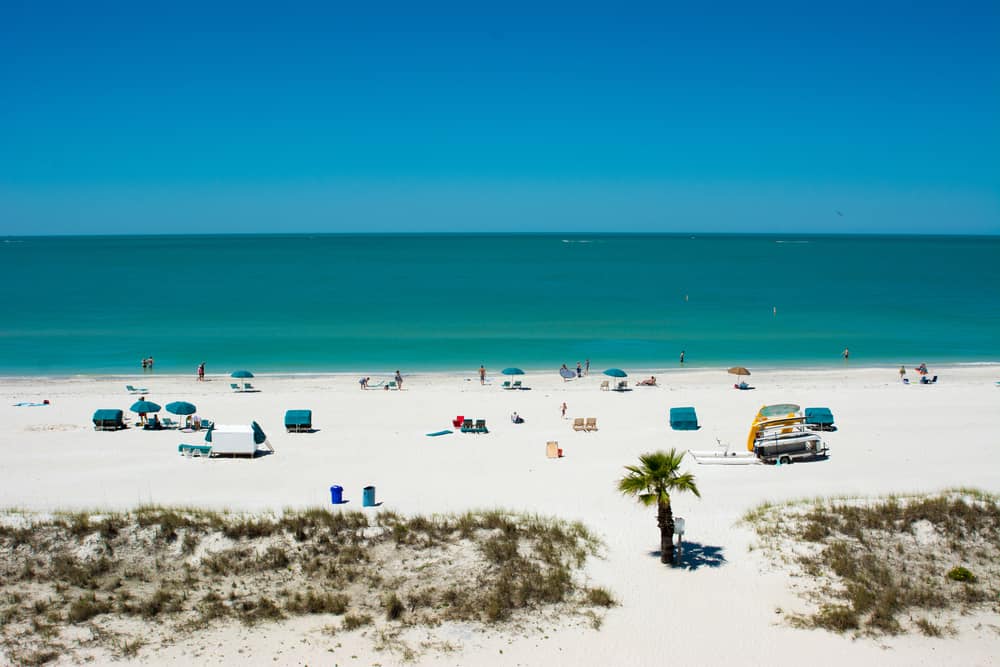 People scattered on the white sand in front of blue water at Treasure Island Beach, which is one of the best things to do in Treasure Island!