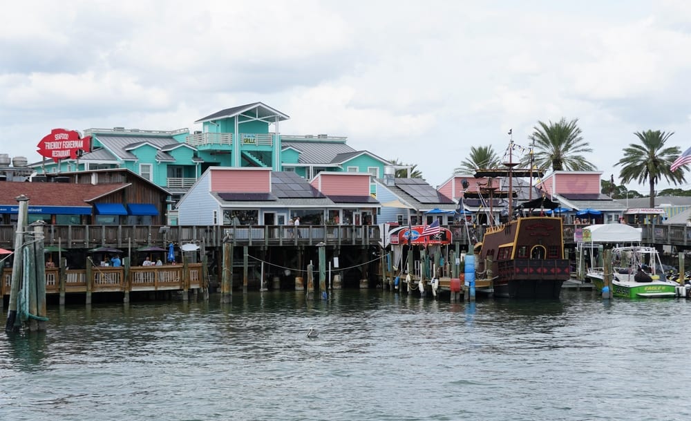 The waterside boardwalk and buildings of Johns Pass, one of the best places to visit near Treasure Island, FL.