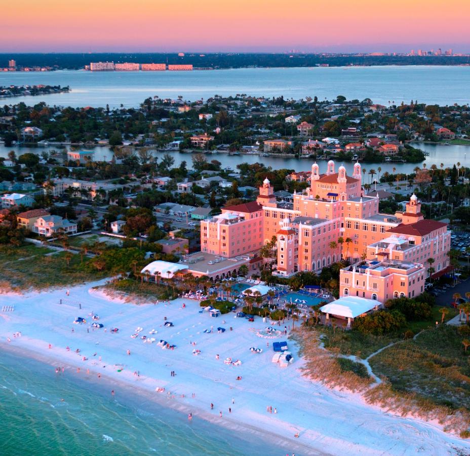 An aerial shot picture of the don Cesar hotel at sunset, the pink of the hotel meshes with the oranges and purples to compliment the beautiful white sand on the beach right in front 