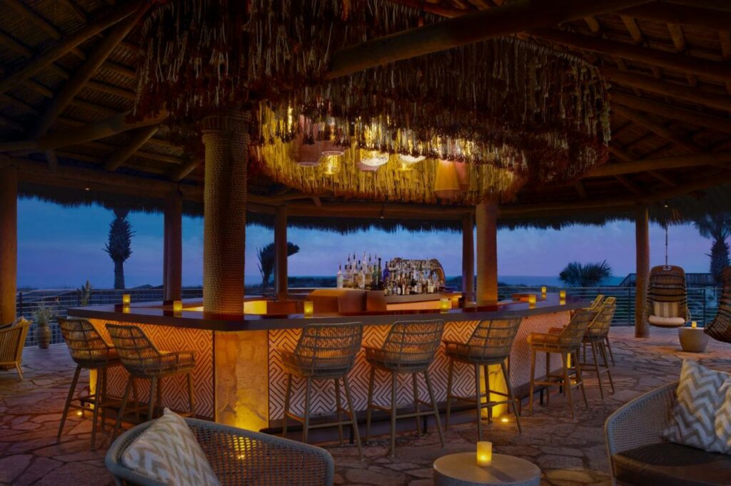 A picture of the ocean-front restaurant at the Ritz-Carlton Amelia Island at sunset, everything is bathed in a warm glow and the ocean in the background fades into the horizon