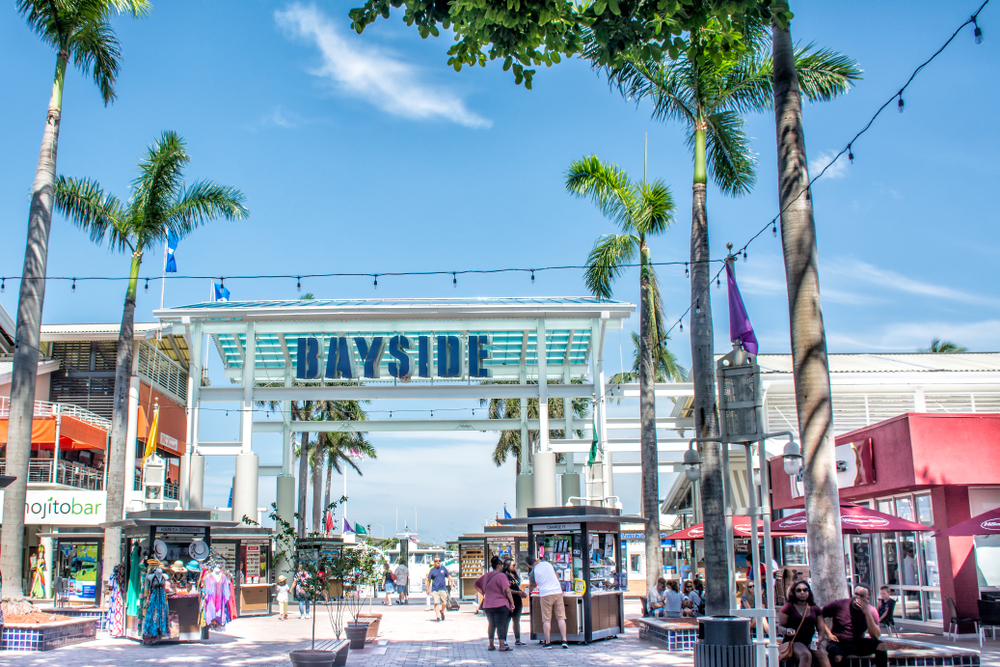 Entrance to the Bayside Marketplace with palm trees and many shops.