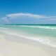 Emerald-colored waves wash up on the clear sand of Henderson Beach State Park, one of the best beaches in Destin.
