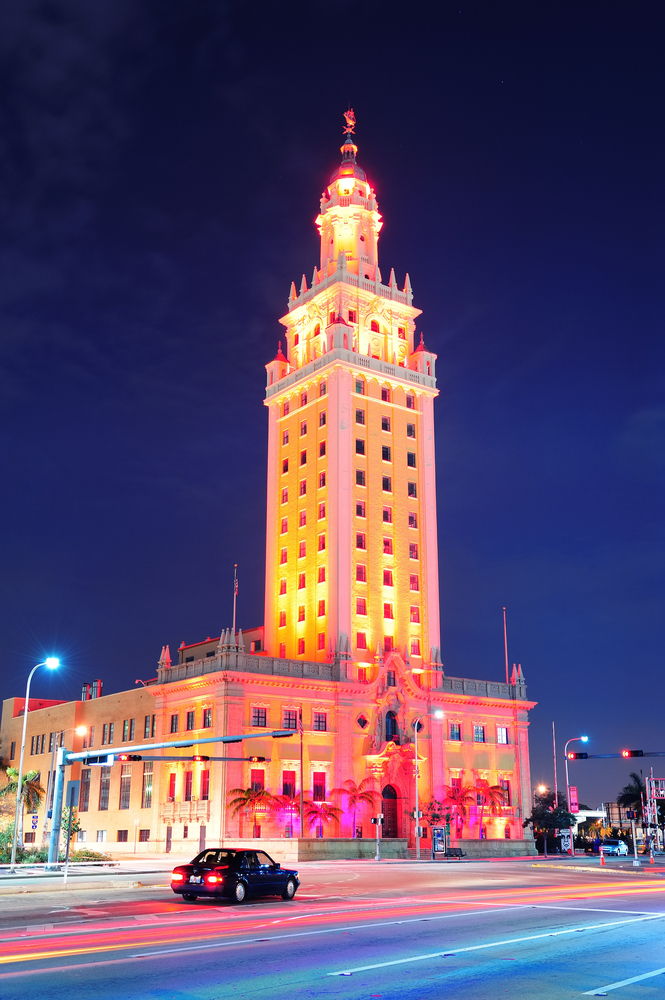 The Freedom Tower lit up with colorful lights at night.