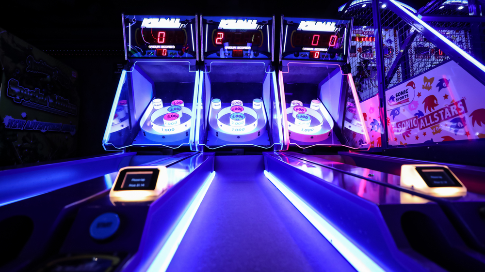 An illuminated set of skiball games in an arcade, like at FunDimension, one of the best things to do in Miami at night.