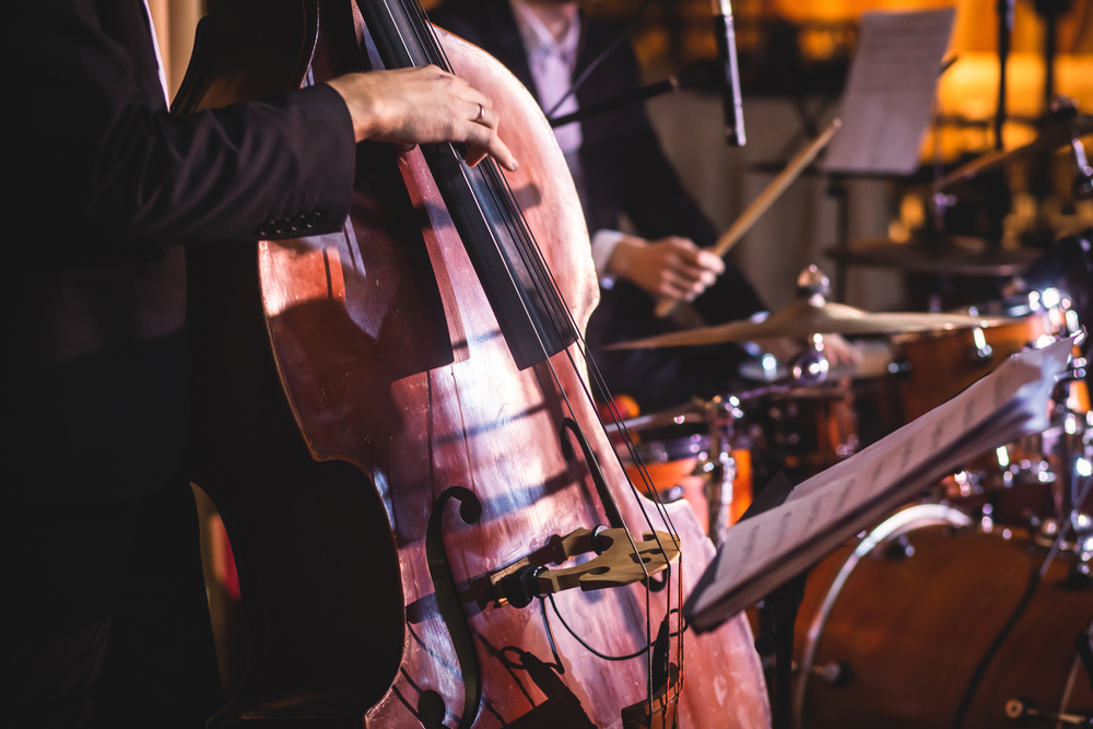 A close up of hands playing a stand up bass during a jazz concert, like the ones at MOCA which is one of the best things to do in Miami at night.