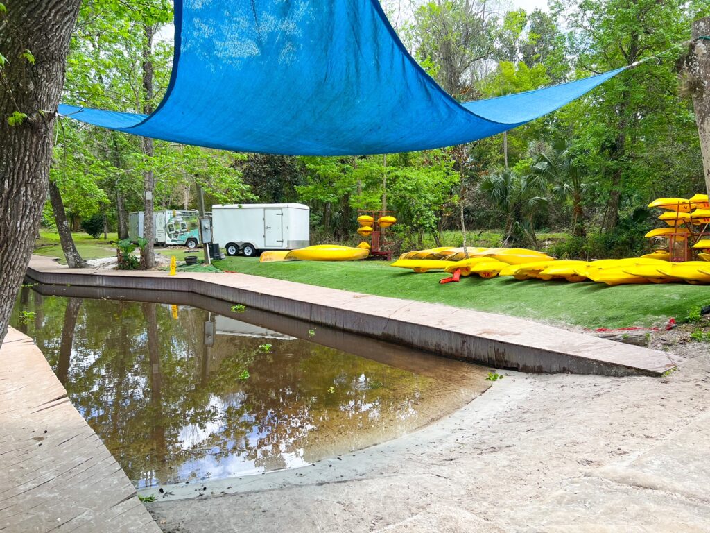 The kayak launch at Kings Landings Florida is easy to maneuver: blue tarp hangs above the launch for protection, the ramp eases into the water, and tons of yellow kayaks are stacked at the side for rental.  