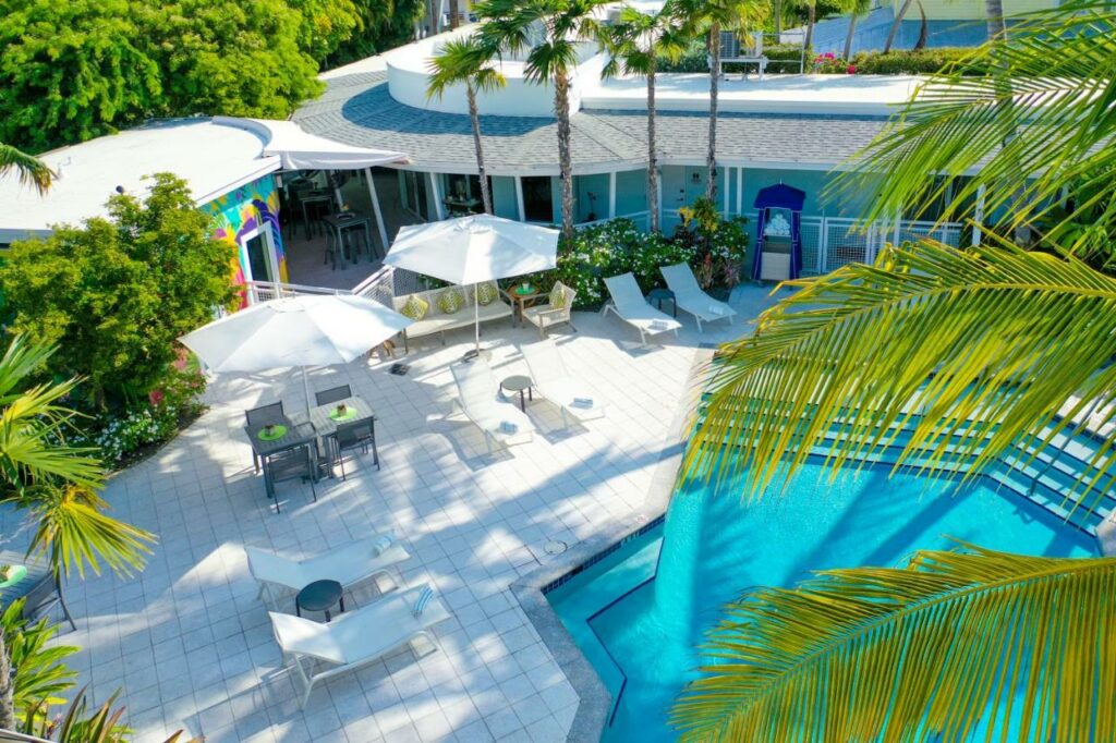 A shot of the Orchid Key Inn's pool area from above, the asymmetrical pool is a stark contrast to the white tiles around it  