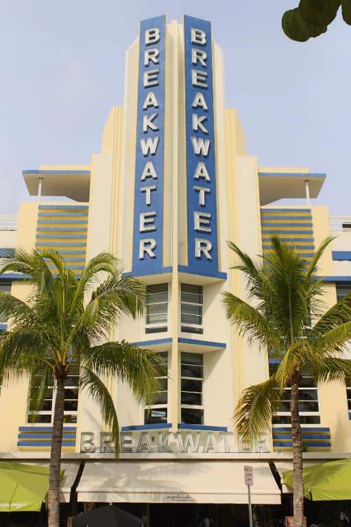 The Art Deco building of the breakwater hotel surrounded by palm trees