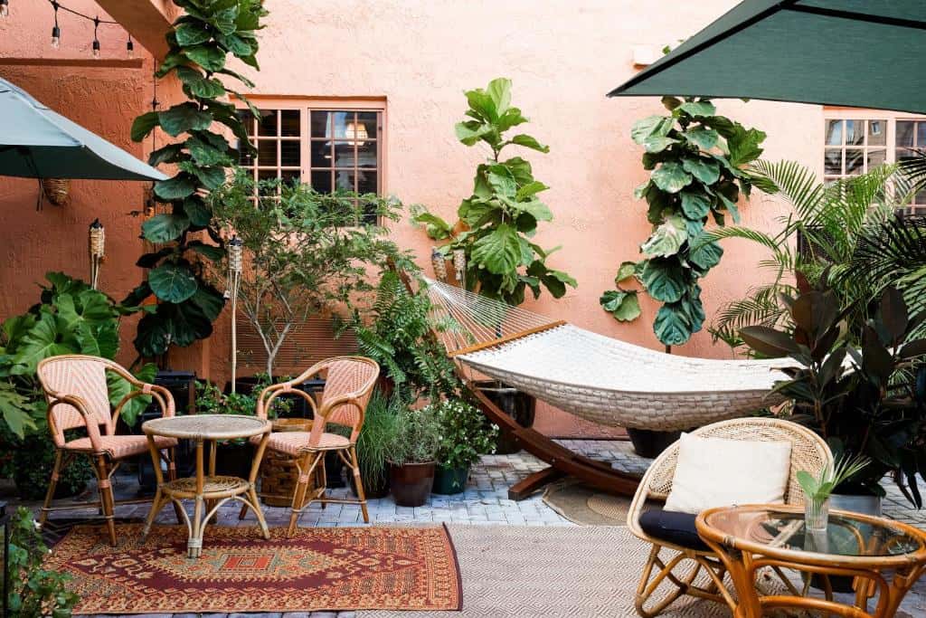 The gorgeous lush garden at one of the places to stay in Little Havana with hammocks, chair and rugs