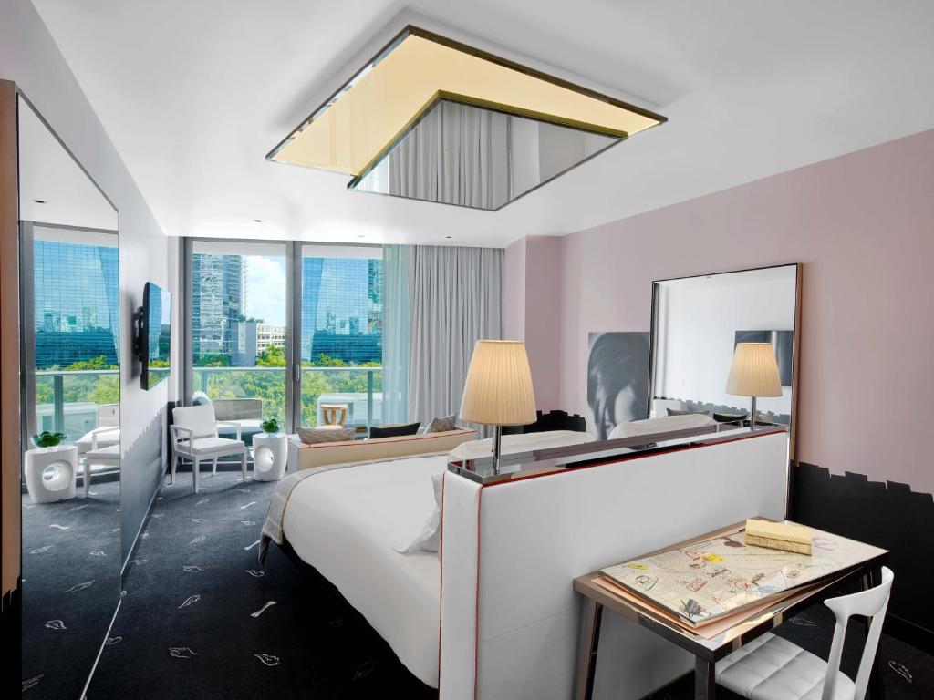 The ultramodern rooms at SLS Miami with bright colors and dark flooring with mirrors and views of the area