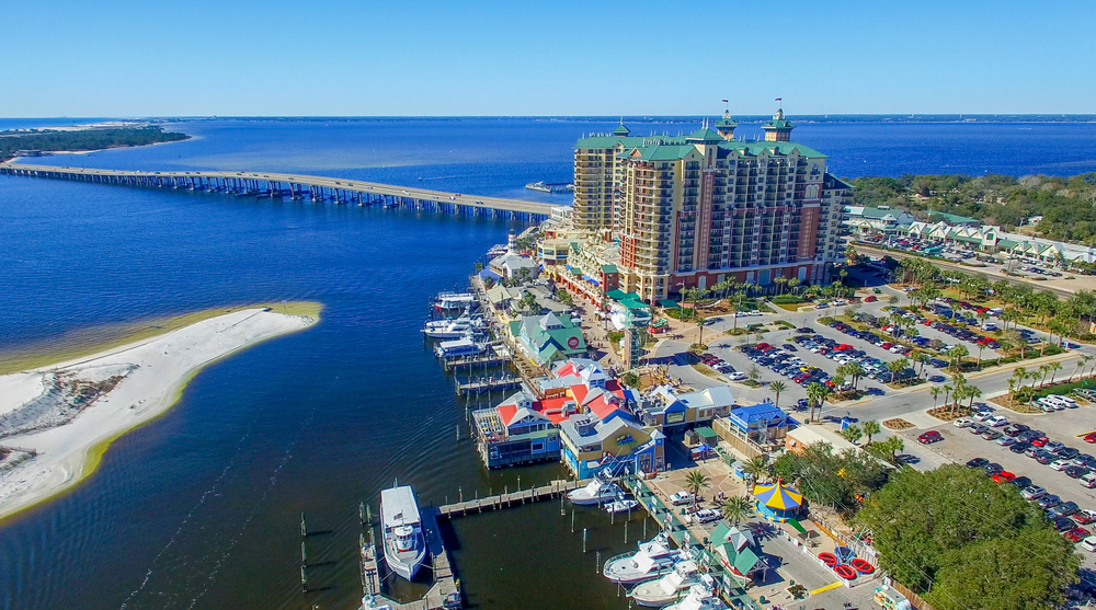 The neighborhoods in Destin are great areas to consider where to stay in Destin, especially those shown in the photos: in this one, downtown Destin shows towering hotels, lots of parking, fishing docks and more. 