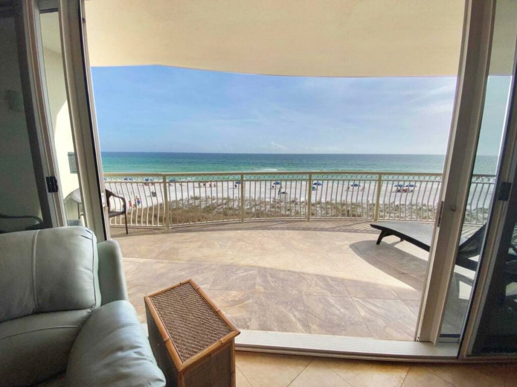 A huge balcony with lounge chairs leans over the white sand beaches and blue waters: places like this make it easy to decide where to stay in Destin. 