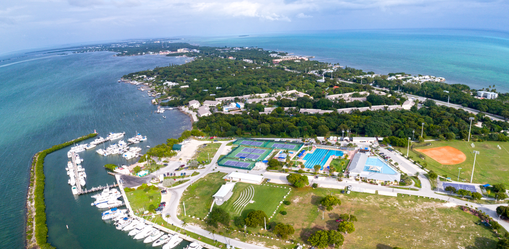 An aerial view of Founders Park in Islamorada, which includes a beach, tennis courts, a swimming pool, and a splash pad.