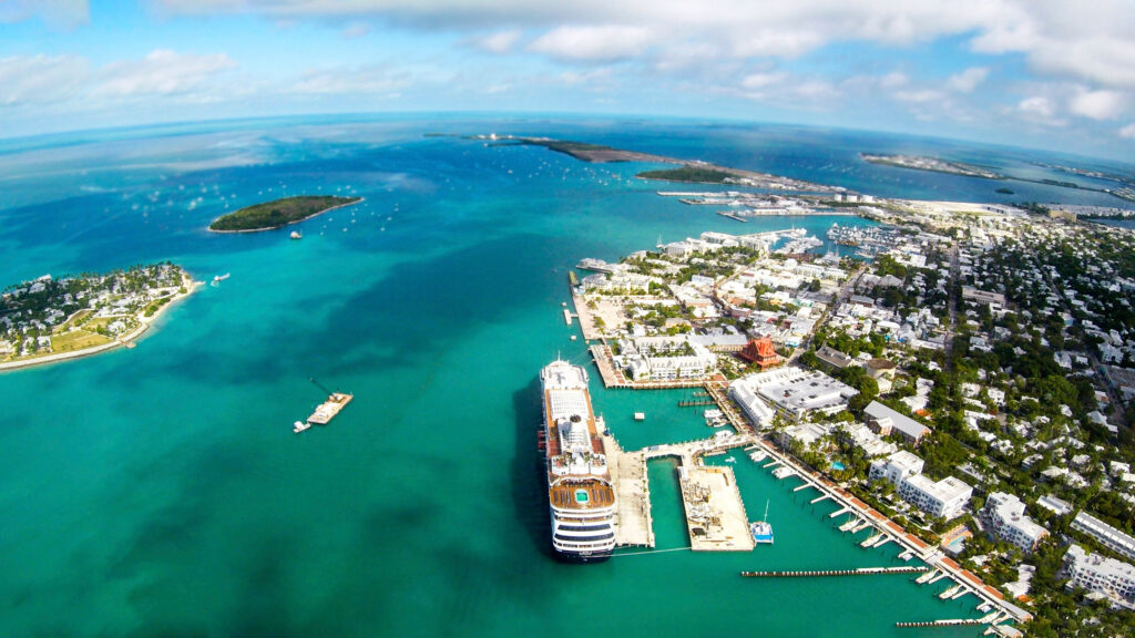 Arial view of Key West Fl with emerald waters, many islands, and a cruise ship
