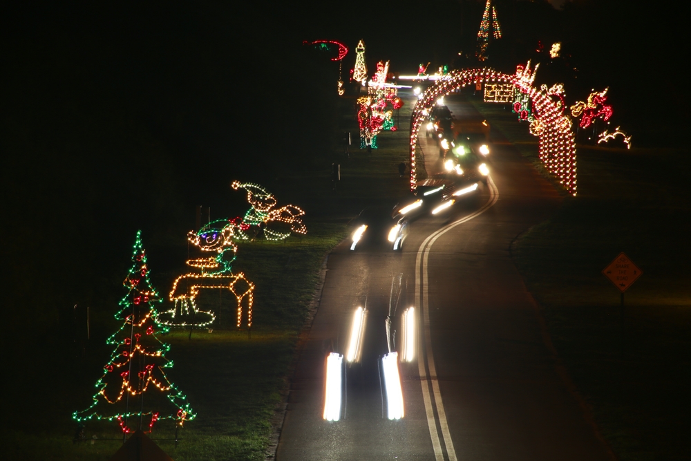 A long exposure shot of cars driving through the Christmas light displays at Fantasy of Lights event in Tradewinds Park Holiday which has some of the best Christmas lights in Florida.
