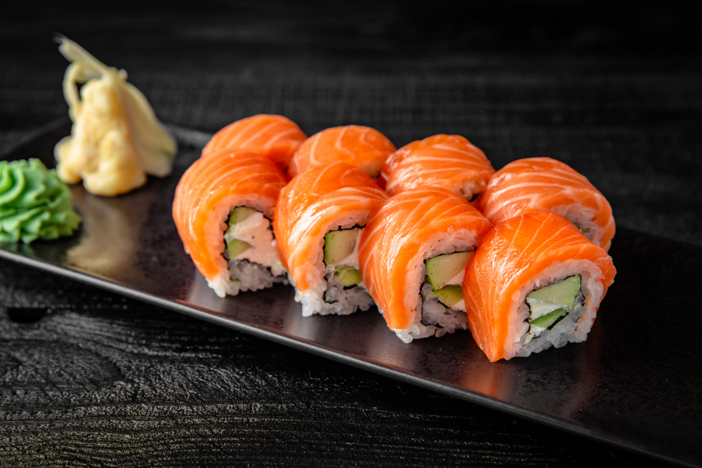 orange sushi rolls served on a black serving plate