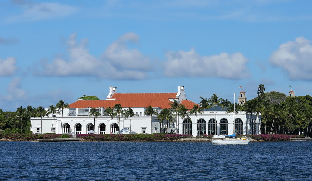 The view of Henry Morrison Flagler Mansion and Museum, a large white home, from the ocean, one of the best things to do in Palm Beach