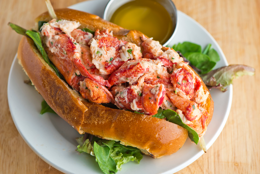 lobster roll sandwich served on a white plate with mustard best restaurants in delray beach