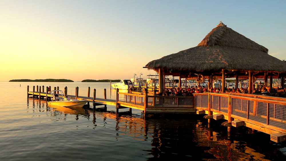 An article on the best restaurants in Islamorada. The picture shows a waterfront restuarant full of people eating. 