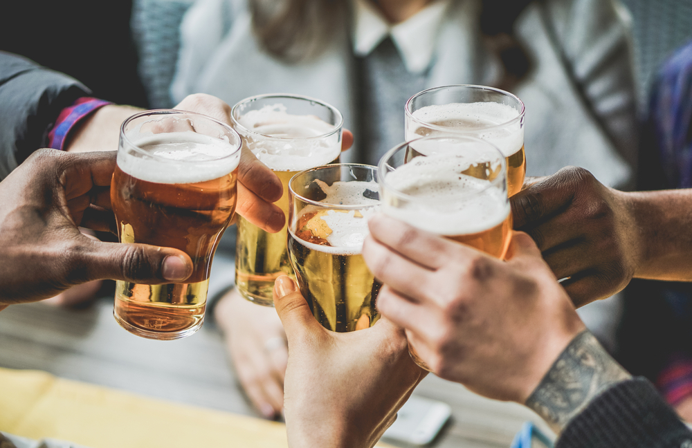 a group of hands cheersing full beer glasses, drinking with friends is always one of the best things to do in the Upper Keys