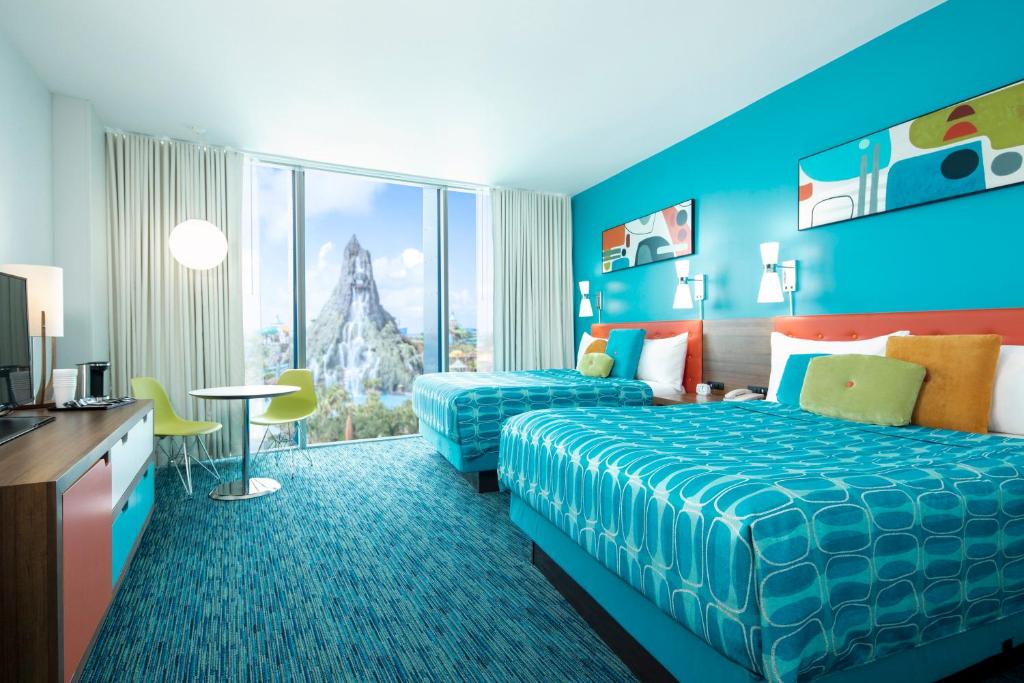 A colorful hotel with bright blue, green, and orange decor. There are large windows where you can see a waterpark. It's where to stay in Florida