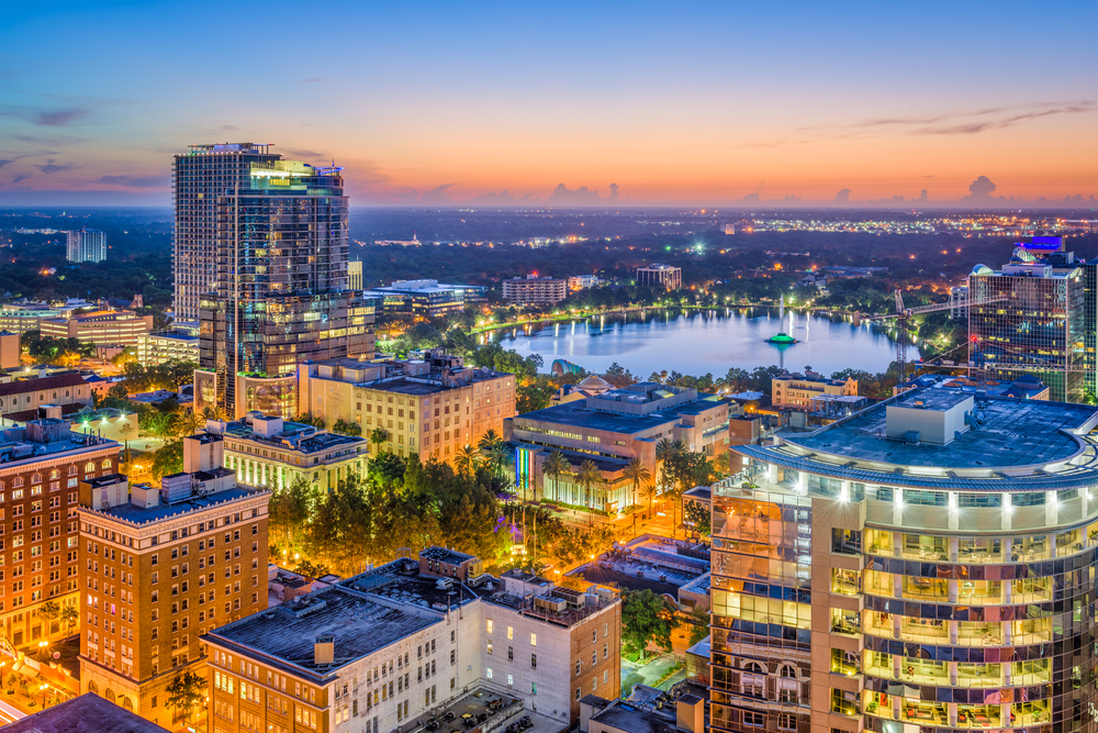 A shot of downtown Orlando at twilight, the lights and sunset combine together to wash the city in gold light