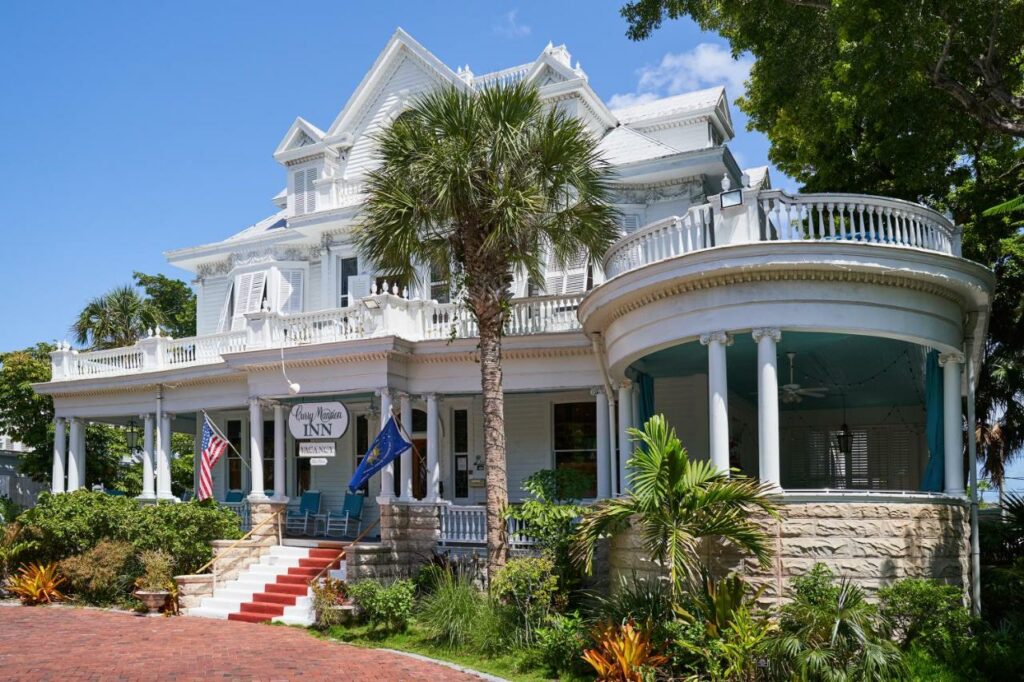 A picture of the Amsterdam's curry mansion  in Key west during the daylight hours, a white building on red pavement