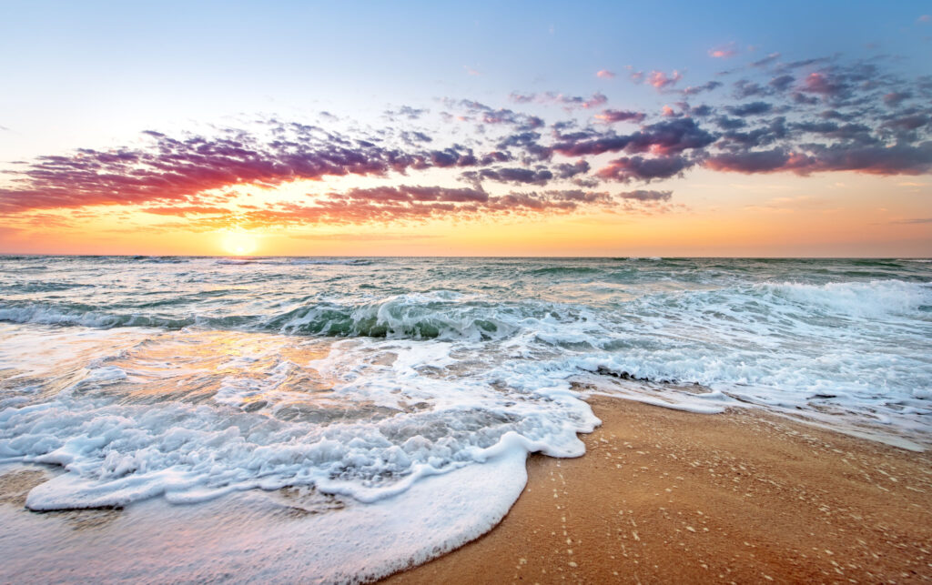 Colorful sunset and flowing waters on the shore of best vacation beaches in North Florida