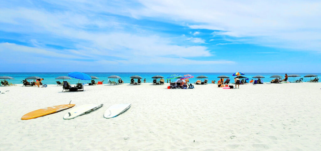 umbrellas and surf boards laid out on a white sand beach on beat beaches on the Gulf Coast