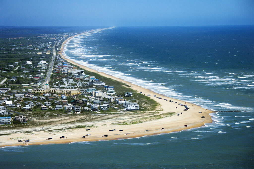 white capped ocean water meeting shores with many parked cars at great beaches in North Florida