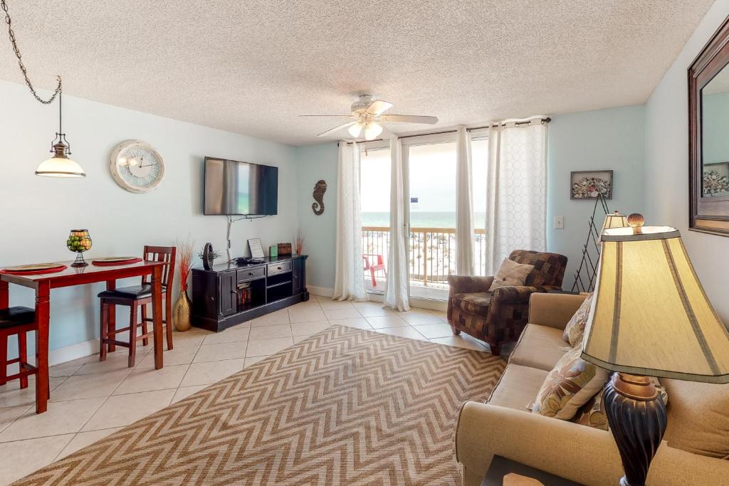 living room with sofa, TV, and a floor-to-ceiling window that overlooks the ocean best beachfront hotels in destin