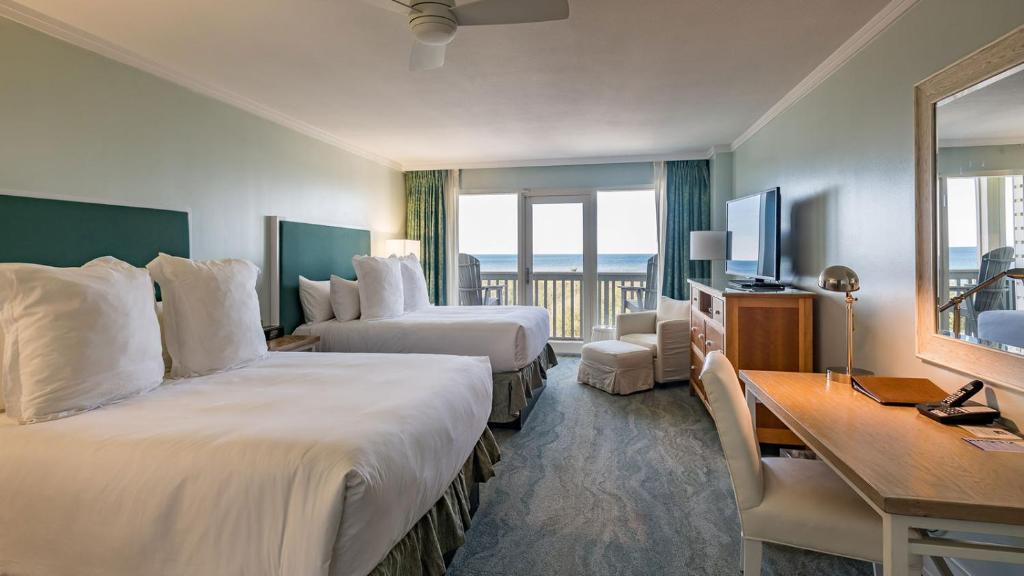 room with two double beds and a small balcony overlooking the ocean best beachfront hotels in destin