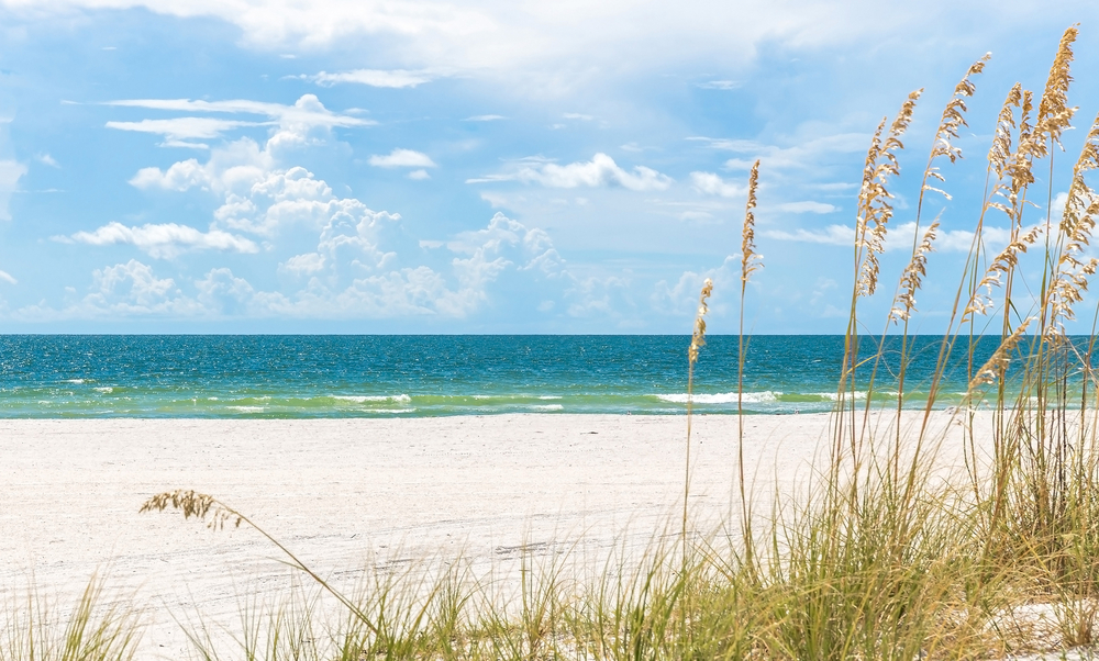 The turquoise water and white sand of a beach on the Gulf of Mexico, which are some of the best beaches to visit in Florida in May.