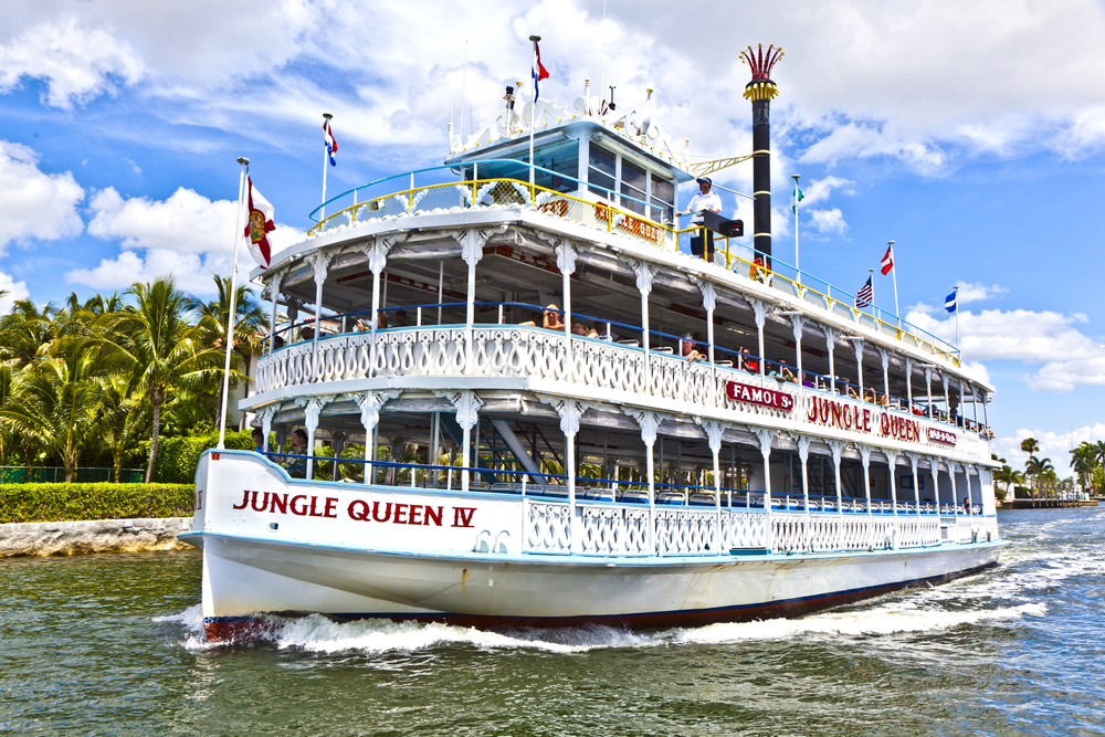 The white double-decker exterior of the Jungle Queen Riverboat, one of the most popular things to do in Fort Lauderdale, as it moves along the water.