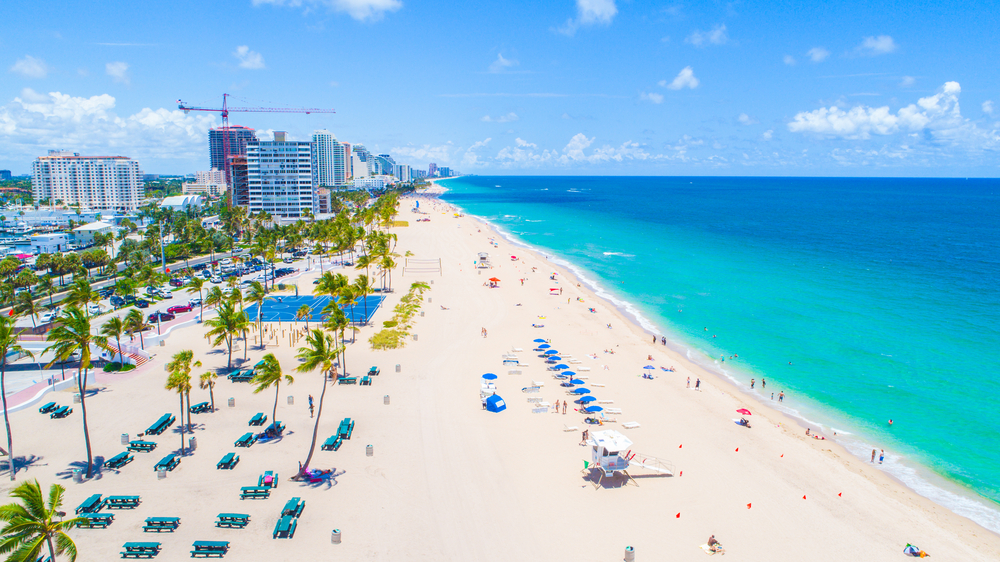 An aerial view of bright turquoise waters of the beach where people swim and sunbathe, one of the best things to do in Fort Lauderdale, FL.