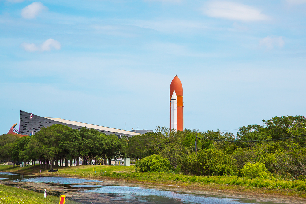 a spaceship in the background and the building at the Kennedy space center