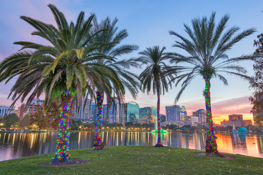 USA downtown skyline at Eola Lake at dusk with palm trees with lights. the article is about the best time to visit Florida 