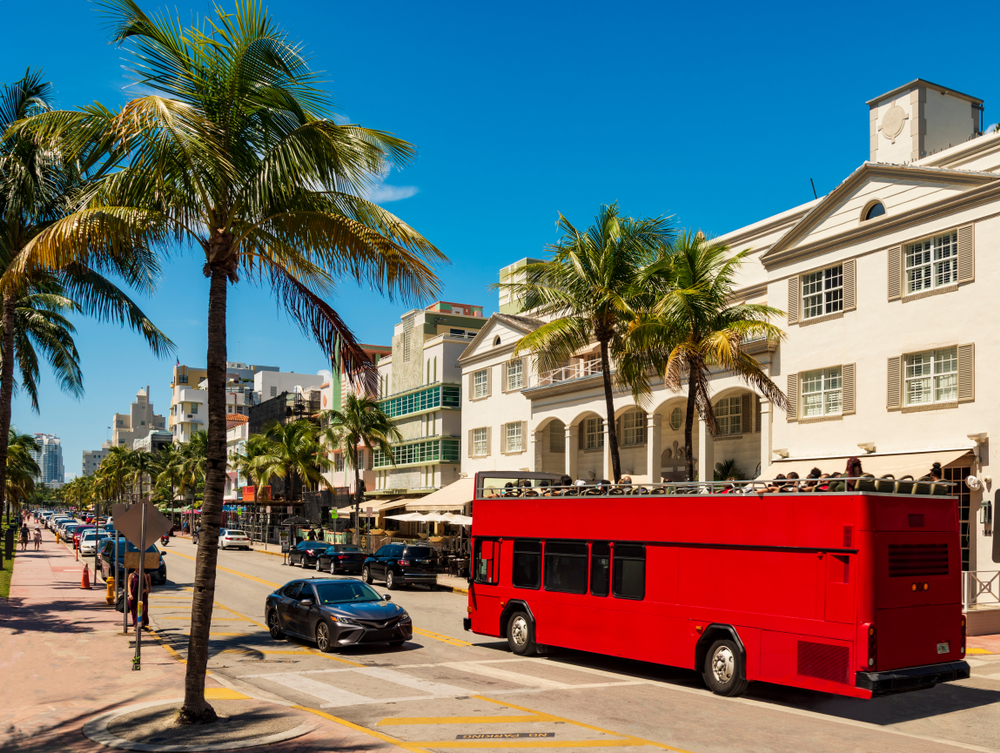 A red open-top tourist bus on a street in Miami that's popular to do in Miami with kids