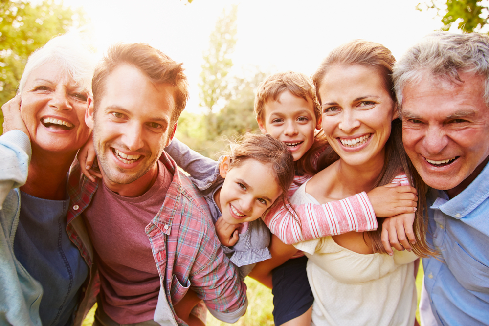 A group of family poses for a close up selfies, they are all smiling. Orlando with kids has so many chances to captures photos and memories like this. 